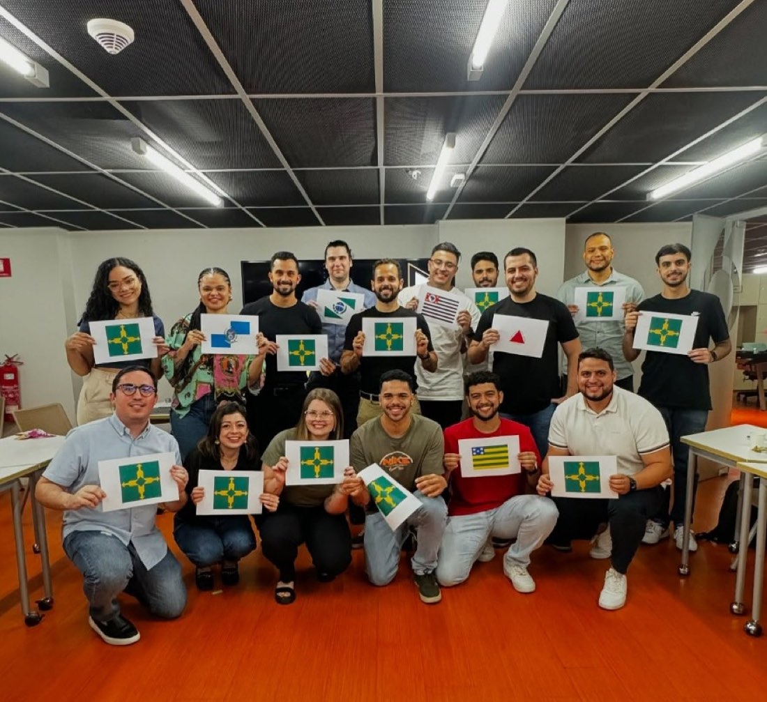 Equipe reunida no escritório, segurando bandeiras do Distrito Federal